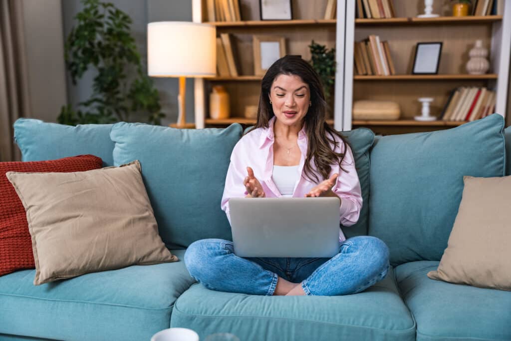 Young woman former victim of domestic violence relax in her apartment has a video call on laptop computer explain and talk about how to reclaim life and have strength to let go of toxic relationships.